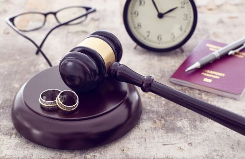 Gavel, rings and money on wooden table - Ashley Wood Law, P.C.