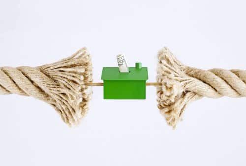 A fraying tug-of-war rope pulling on a house with US Dollar bills. - Ashley Wood Law, P.C.