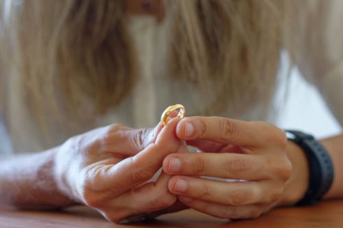 Woman's hands holding a golden wedding ring. Concept for Does Domestic Violence Affect Your Divorce?