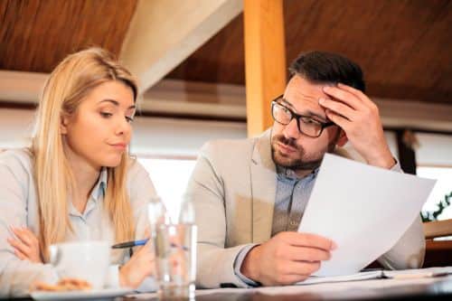 Couple facing a divorce going over documents. Visual concept for a legal blog discussing divorce and the small business owner.