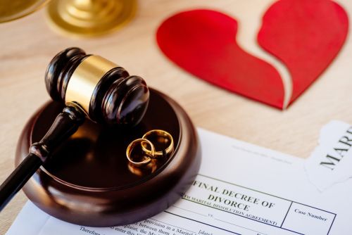Two broken golden wedding rings on judge gavel. Visual concept for a legal blog discussing the benefits of a post Divorce Checklist reminding you to notify financial institutions and government agencies about changes in your marital status, name, or address.