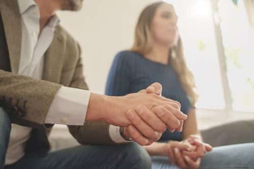 An anxious couple. Close up of the man's hands. Visual concept for a family law blog discussing the key differences between collaborative and traditional divorce.