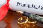 Prenuptial agreement papers with wedding bands - Ashley Wood Law, P.C.