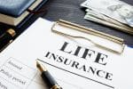 Whole life insurance pen and dollar banknotes. Concept for Divorce and Life Insurance: What You Need to Know