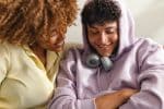 Portrait of a mother sitting on the sofa and hugging her teenaged son. Visual concept for a blog discussing does child support end at 18?